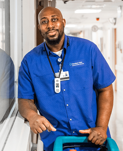 A male EVS Technician holding a floor buffer in a hospital hallway