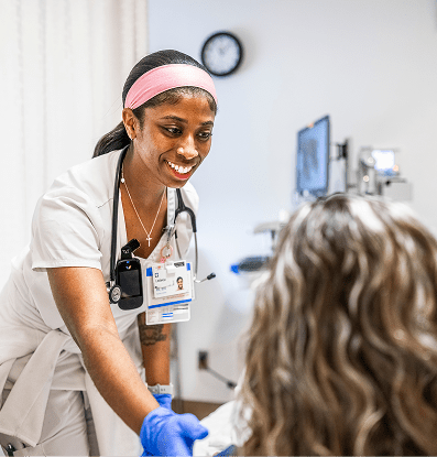 Smiling female nurse caring for a patient at the patient's bedside