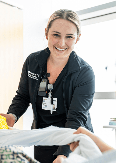 A smiling female physical therapist working with a patient